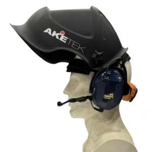 Ett mannekänghuvud bär en svart Svetshjälm AKETEK® AUDIO-hjälm avsedd att användas med hörselkåpor, med ansiktsskydd och ett blått headset med mikrofon, mot en vit bakgrund.